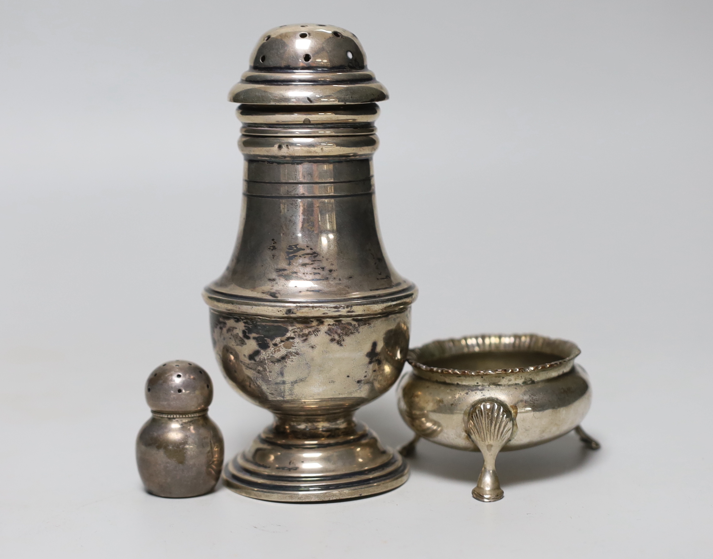A George V silver baluster sugar caster, E.S. Barnsley & Co, Birmingham, 1910, 13.9cm, a silver salt and a sterling condiment, 5.5oz.